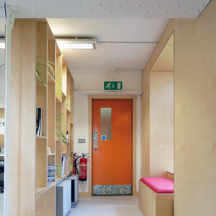 Ante chamber behind wooden office shelves leading to a fire escape