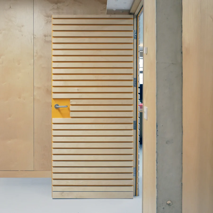 Crenellated wooden office door ajar