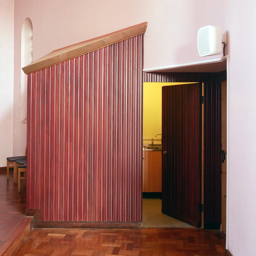 Kitchenette with a table and sink behind door