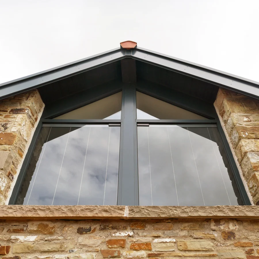 Looking up at large double window under roof arch