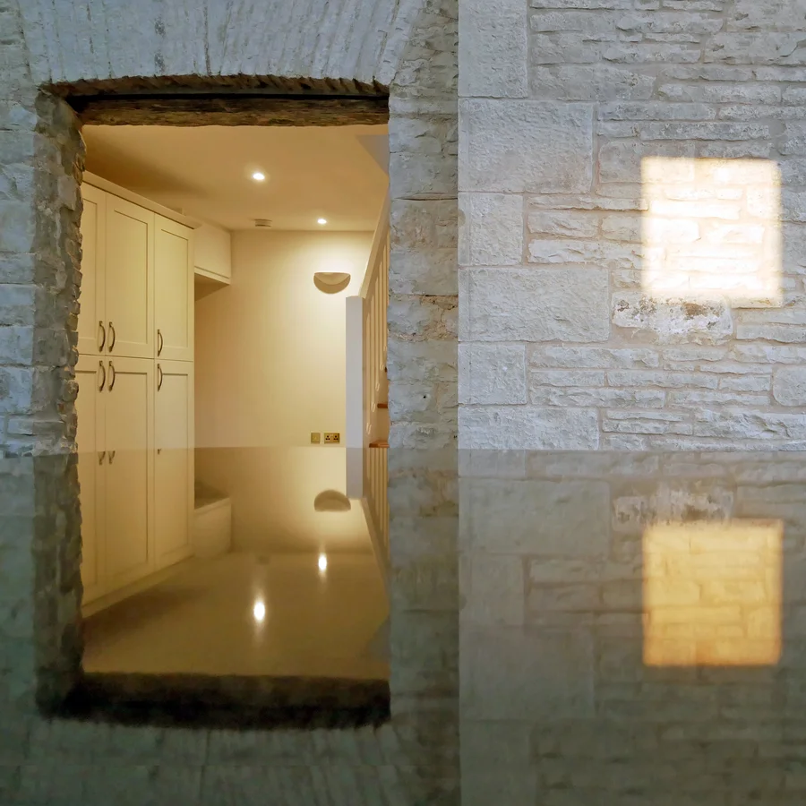 Marble kitchen worktop reflecting lit room and stone wall